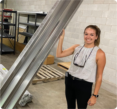 Lady in the Better Exteriors Warehouse holding one of the materials for Batter Exteriors products