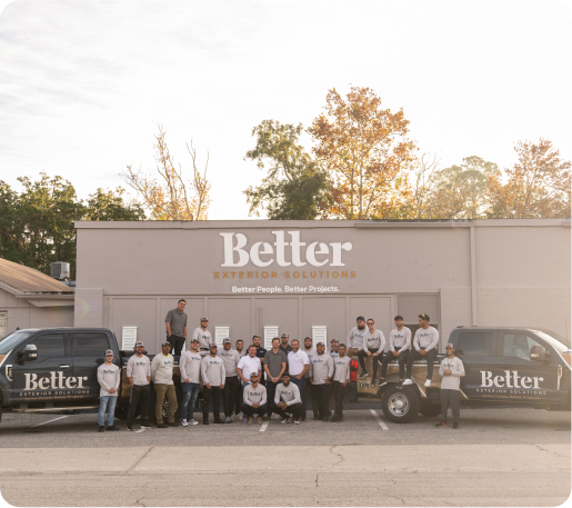 The Better Exteriors Team outside their warehouse all the staff and both their branded trucks